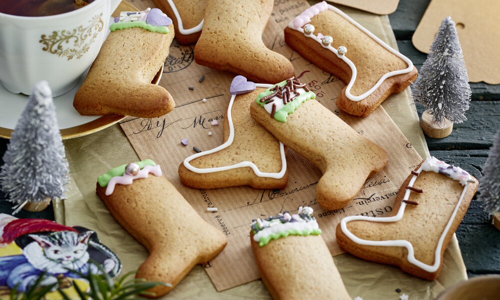 Viele Kekse in Form von Stiefel, in weihnachtlicher Umgebung, daneben Tee in Tasse. | © 	Isabell Triemer