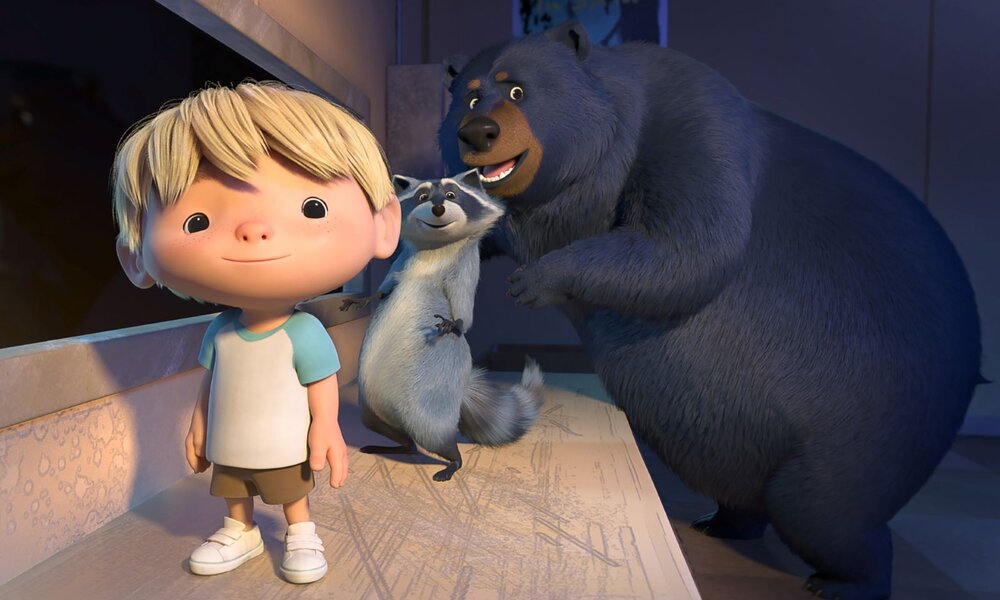 Ein animierter Junge mit blonden Haaren steht lächelnd neben einem Waschbären und einem großen Bären in einem beleuchteten Raum. | © NETFLIX  / TrashTruck 