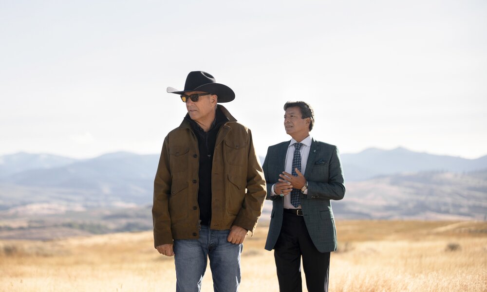 Kevin Costner und ein Co-Star vor einer weiten, grandiosen Landschaft in einer Szene aus der Paramount Serie "Yellowstone" - Staffel 5 | © Paramount+