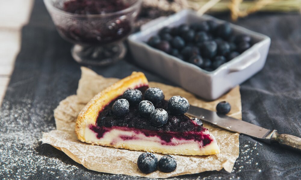 Geschnittenes Stück Käsekuchen mit Blaubeeren, | © Getty Images / victoriabee