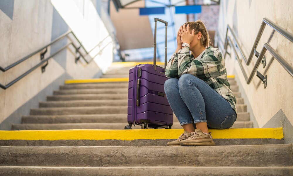 Frau sitzt verzweifeln auf einer Treppe am Bahnhof | ©  Getty Images / LittleBee80