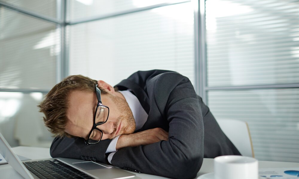 Mann schläft am Schreibtisch | ©  Getty Images / shironosov