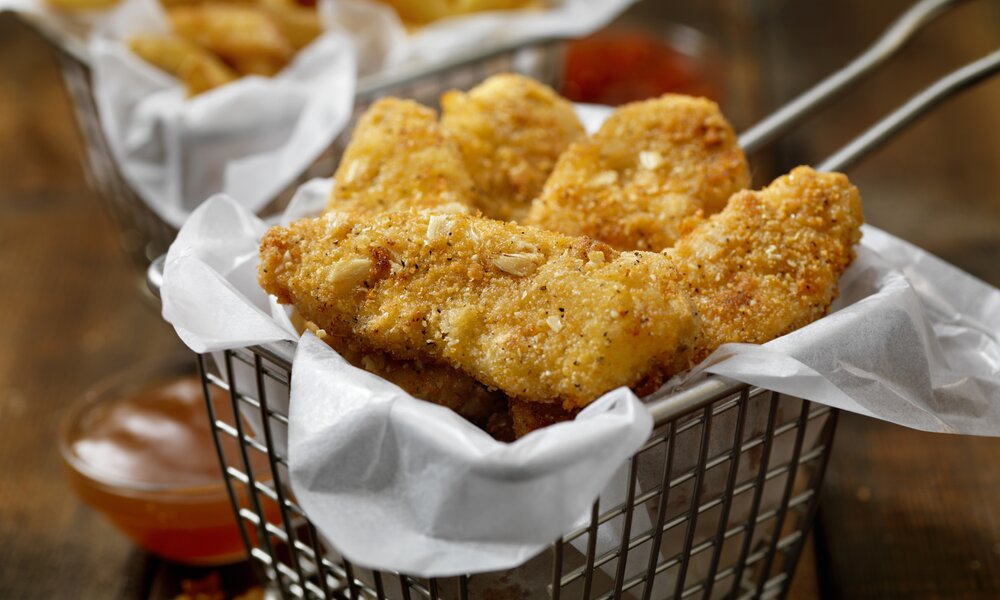 Knuspriger Genuss in 10 Minuten: Blitzschnelle Hähnchen-Nuggets aus der Heißluftfritteuse | © Getty Images / LauriPatterson Hähnchen-Nuggets in Körbchen. | © Getty Images / LauriPatterson