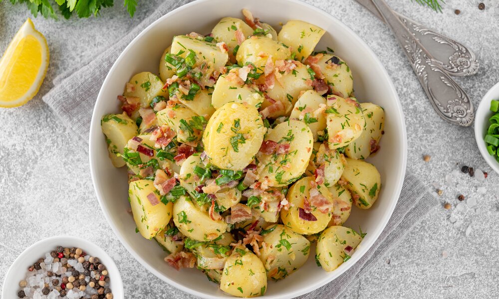 Kartoffelsalat ohne Mayo angerichtet in einer Salatschüssel. | © Adobe Stock / irina2511