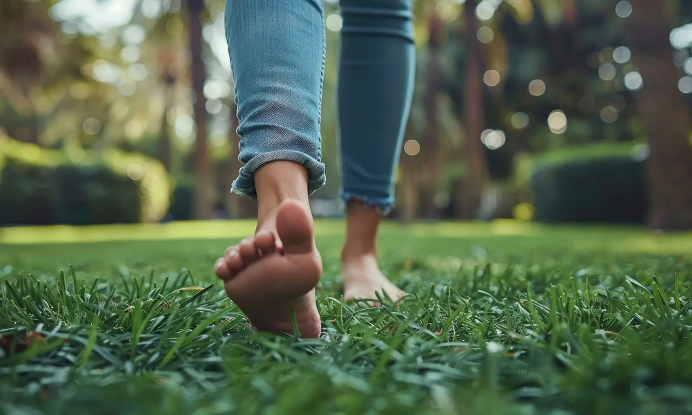 Frau läuft Barfuß über den Rasen | © stock.adobe.com/AdriFerrer
