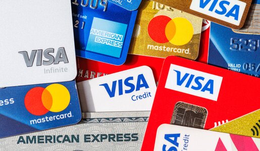 Verschiedene Kreditkarten von Visa, Mastercard und American Express liegen teils übereinander in einem Stapel. | © IMAGO/Aviation-Stock