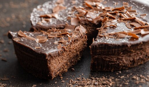Angeschnittener Frischkäse-Schokokuchen mit einer Schokoglasur und Schokoraspeln on top. | © Adobe Stock / Jiri Hera