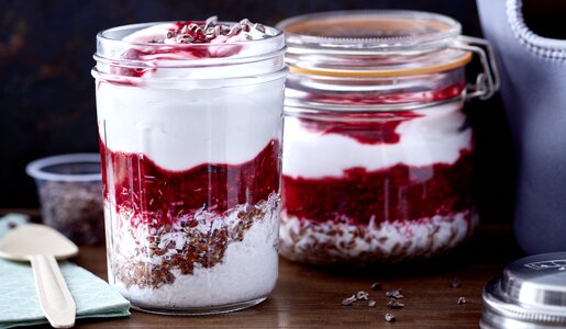 Zwei Gläser gefüllt mit einer Mixtur aus Himbeeren, Joghurt und Kokos auf einem Holzuntergrund. | © 	Johannes Reinecke