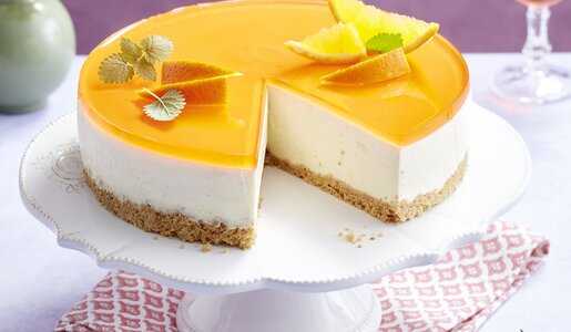Angeschnittener Aperol Spritz Käsekuchen ohne Zucker auf einem Kuchentablet. | © Isabell Triemer