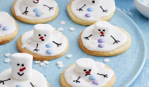 Mehrere Schneemann-Kekse mit Marshmallows auf einem Teller in blauer, winterlicher Atmosphäre. | © 	Isabell Triemer