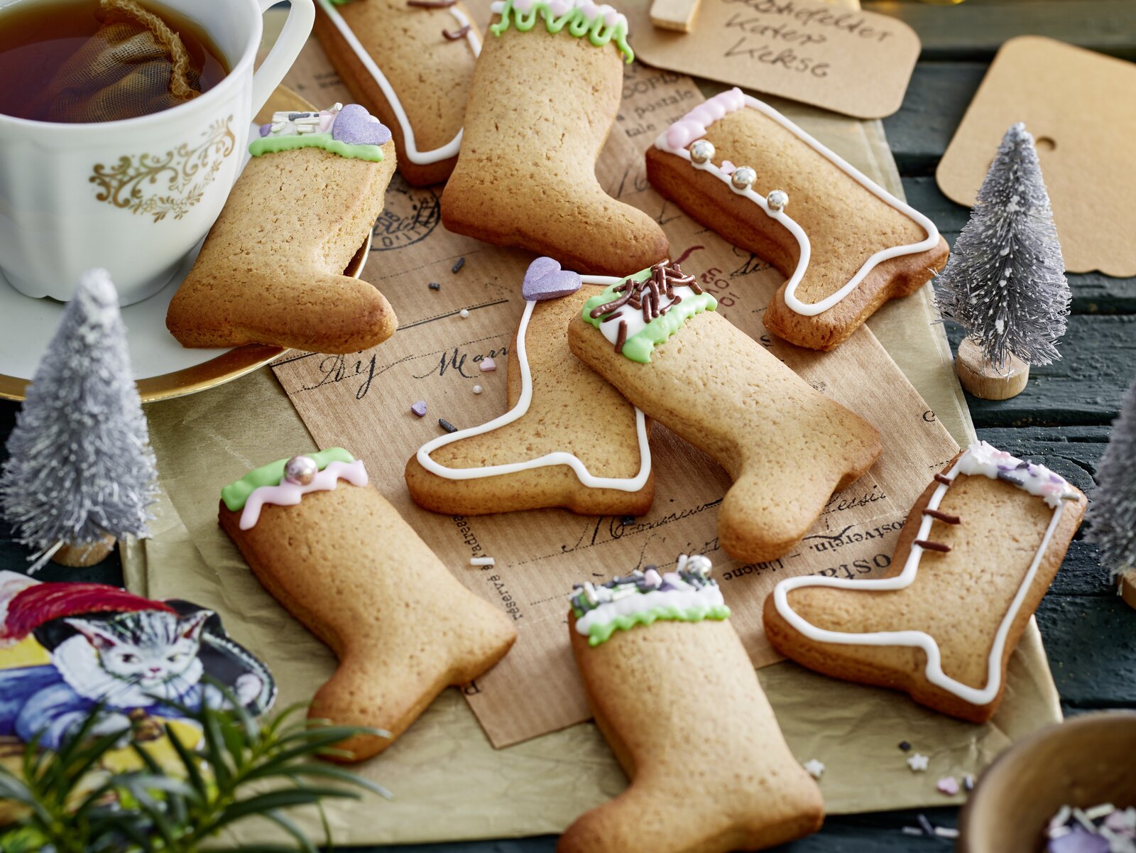Viele Kekse in Form von Stiefel, in weihnachtlicher Umgebung, daneben Tee in Tasse. | © 	Isabell Triemer