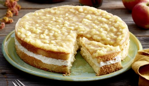 Apfel-Schmandkuchen in Nahaufnahme, oben auf dem Kuchen ein Apfel-Kompott-Spiegel, mit Cremefüllung und Biskuitboden. | ©  Isabell Triemer