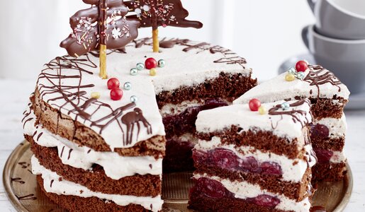 Angeschnittene Schwarzwälder Glühwein-Kirschtorte auf einem Kuchenteller, in festlicher Umgebung. | © Isabell Triemer
