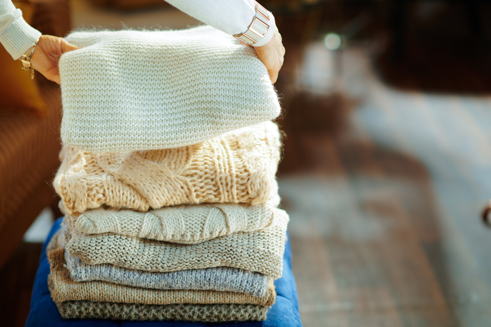 ein stapel mit warmen winterpullovern | © Adobe Stock/ Alliance