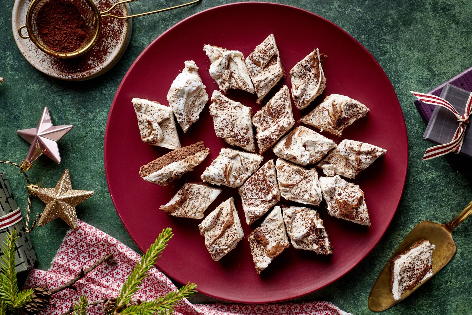 Mehrere Nougat-Baiser-Kekse auf einem Teller angerichtet in weihnachtlicher Umgebung. | ©  Isabell Triemer