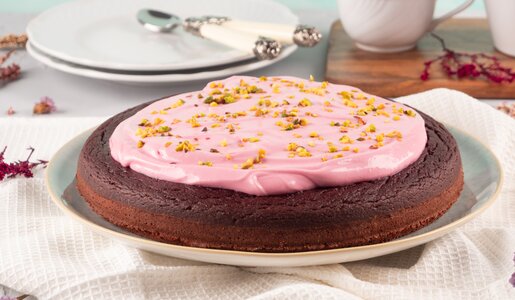 Rote Bete Kuchen mit rosa Frosting auf einem Tisch mit Besteck und. | © Adobe Stock / tenkende