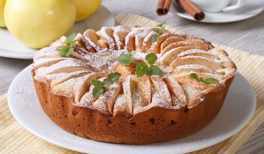Luftiger Apfel-Quarkkuchen auf einem Holztisch. | © Getty Images / ALLEKO