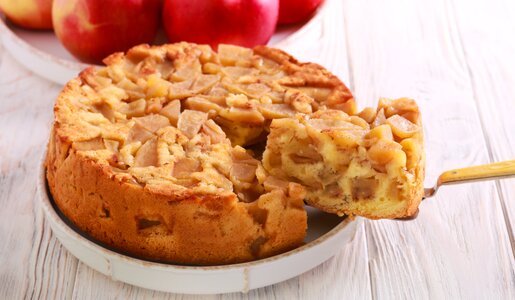 Ein Kuchen mit einem herausgeschnittenen Stück davor. | © Adobe Stock / manyakotic