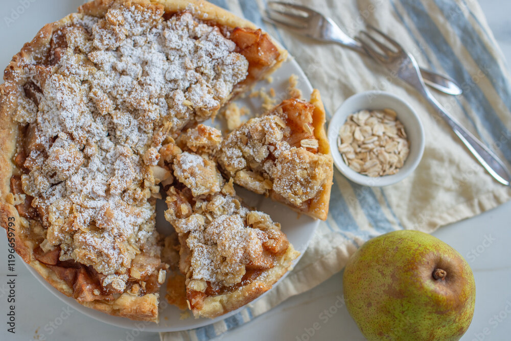 Angeschnittener Apfel-Streuselkuchen von Oben, daneben frische Äpfel. | © Adobe Stock / A_Lein