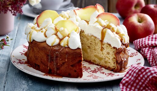 Angeschnittene Apfel-Creme-Torte mit Apfelstücken und Karamellsoße. | © Isabell Triemer