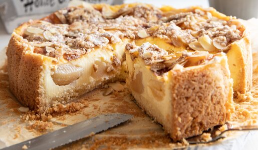Angeschnittener Apfelkuchen auf einem Holztisch. | © Adobe Stock / Kerstin