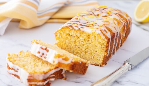 Angeschnittener Zitronenkuchen mit Zitronenkuss auf einem Kuchengitter. | © Getty Images / Cris Cantón