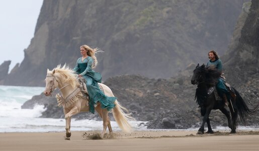 Morfydd Clark als Galadriel und Lloyd Owen als Elendil reiten über einen Strand in einer Szene der Prime Video Serie "Der Herr der Ringe: Die Ringe der Macht§ | © Amazon Studios/Prime Video