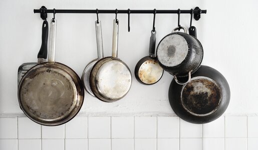Alte Töpfe und Pfannen hängen an der Wand | ©  Getty Images / Carlina Teteris