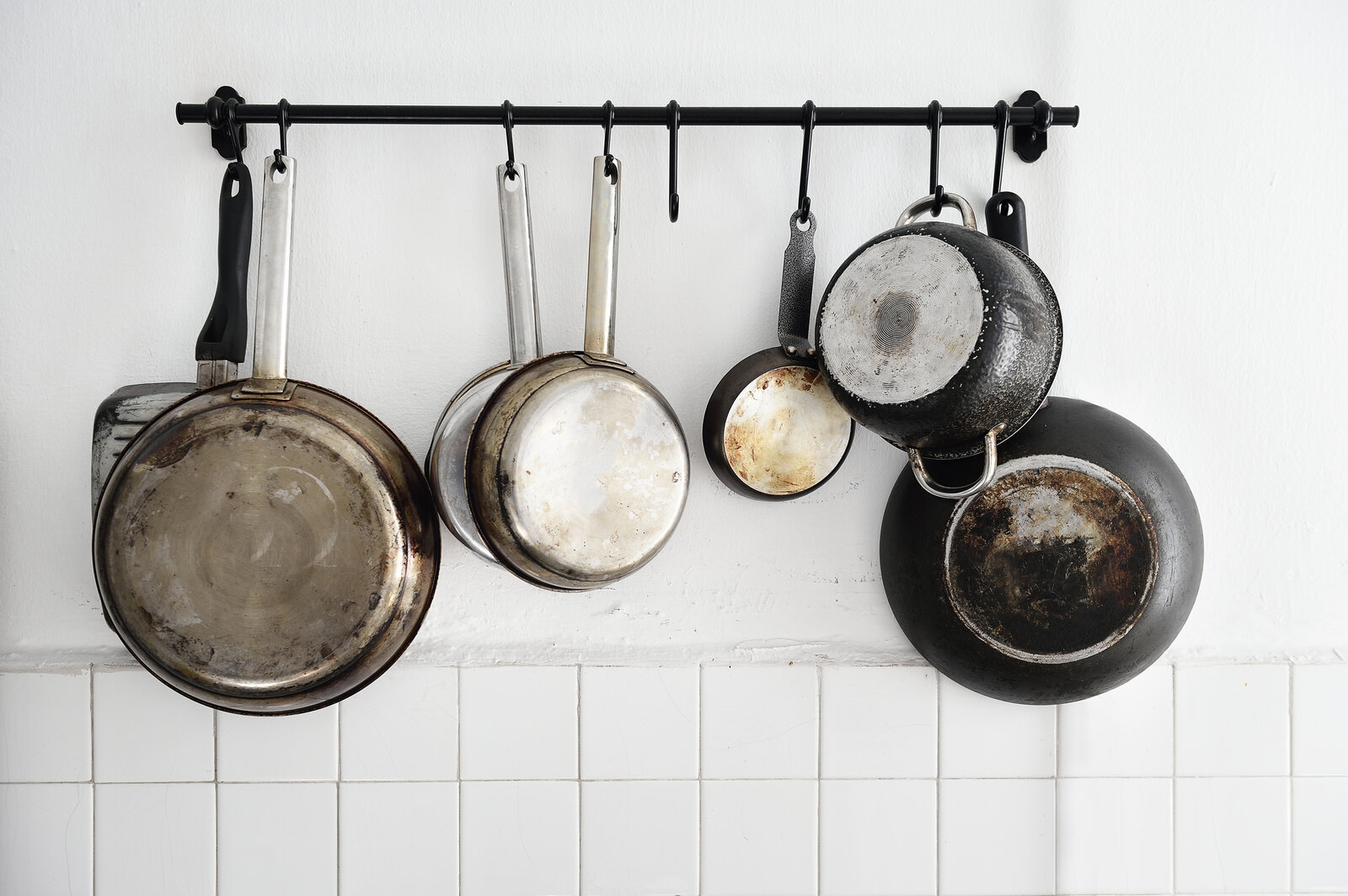 Alte Töpfe und Pfannen hängen an der Wand | ©  Getty Images / Carlina Teteris