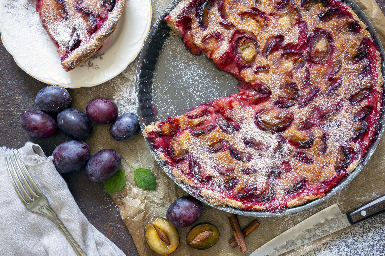 Aufgeschnittener Zwetschgen-Kuchen in einer Form. | © Getty Images / alle12
