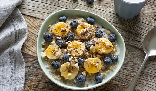 Eine Schüssel voller Porridge, belegt mit Bananenscheiben. | © Getty Images / BURCU ATALAY TANKUT