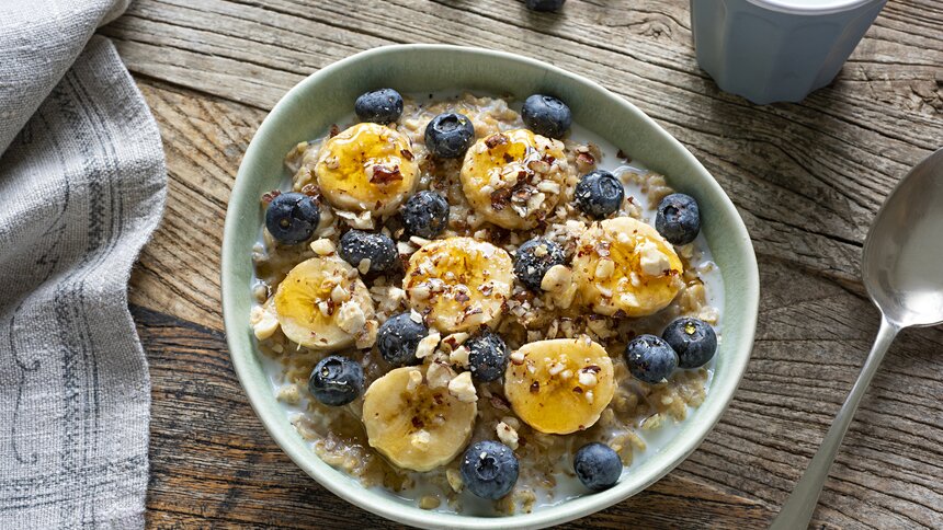 Eine Schüssel voller Porridge, belegt mit Bananenscheiben. | © Getty Images / BURCU ATALAY TANKUT