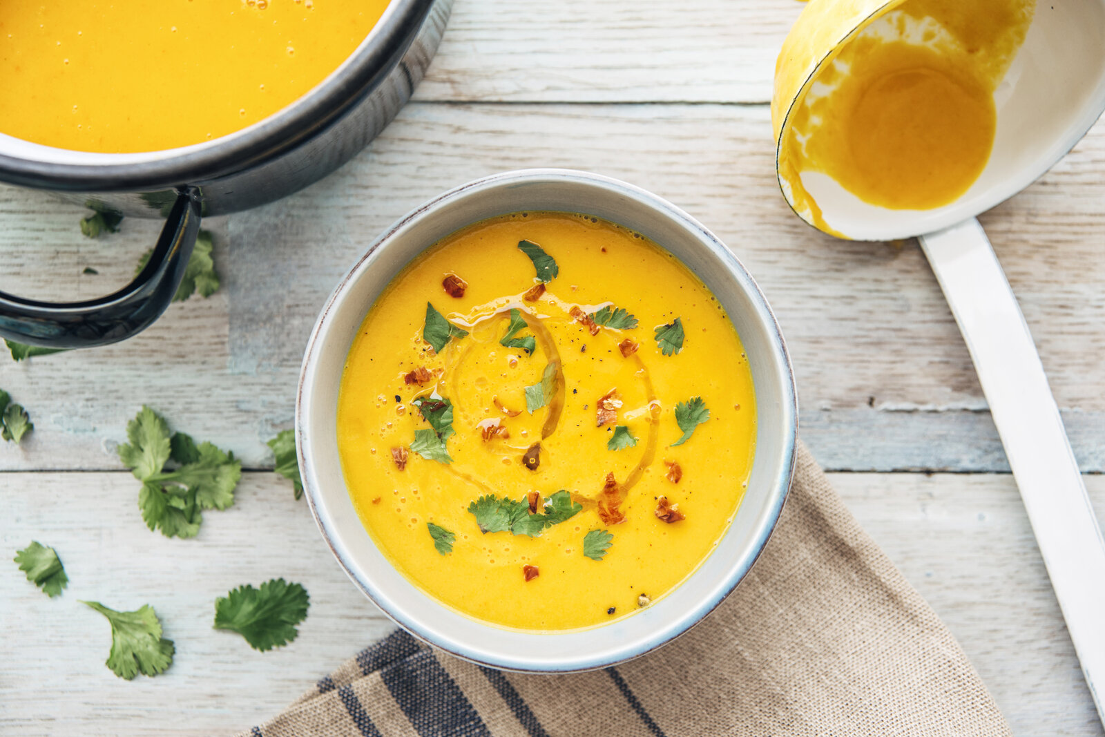 In einer Schale angerichtet befindet sich Kürbissuppe bestreut mit Petersilie. | © Getty Images / Westend61