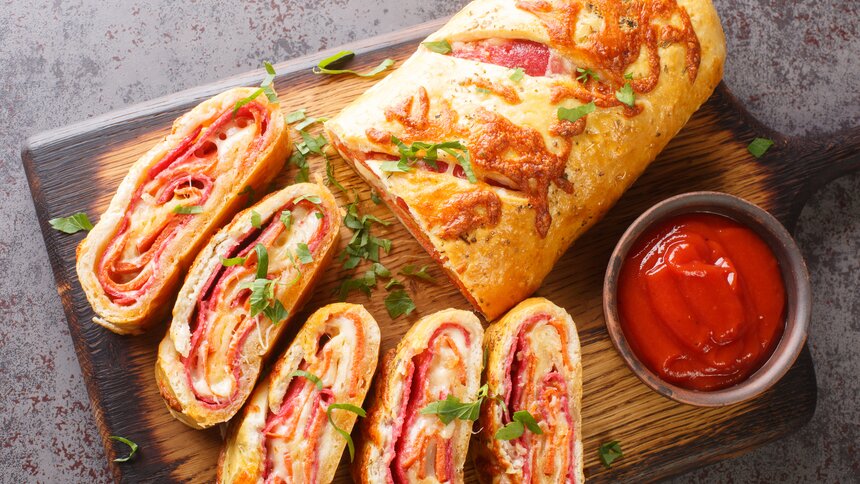 Aufgeschnittener herzhafter Strudel mit Schinken. | © Getty Images / ALLEKO