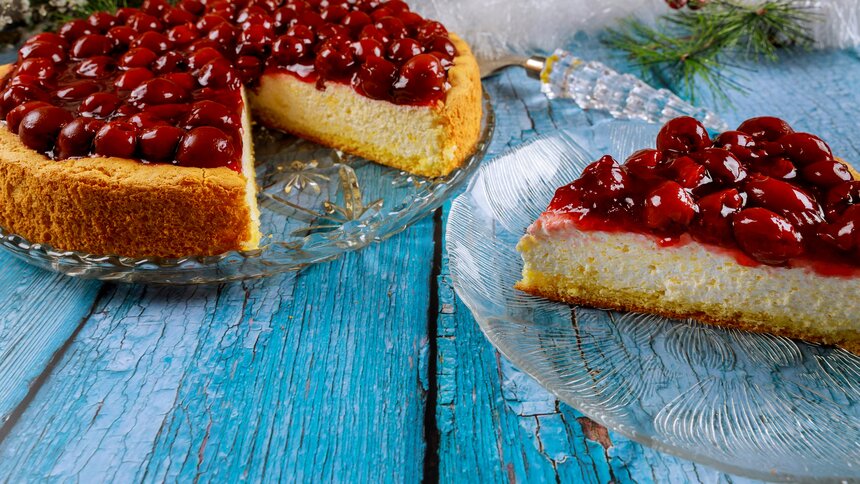 Angeschnittener Kirschkuchen auf einem alten Holzuntergrund in Blau. | © Getty Images / 500
