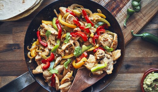 Paprika-Streifen und Hähnchen, knusprig angebraten in einer Pfanne angerichtet. | © Getty Images / GMVozd