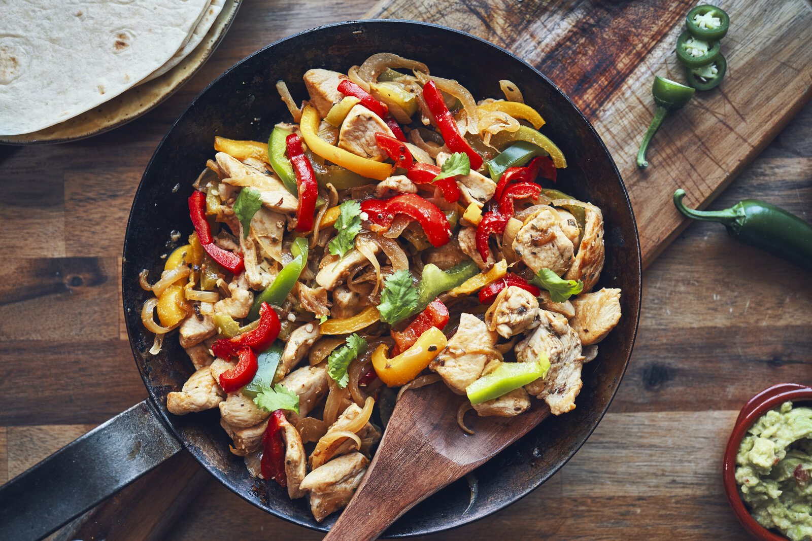 Paprika-Streifen und Hähnchen, knusprig angebraten in einer Pfanne angerichtet. | © Getty Images / GMVozd