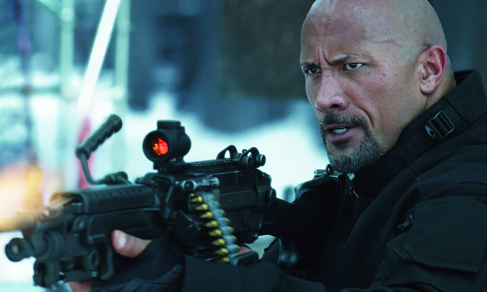 Dwayne Johnson mit schwerer Waffe im Anschlag in einer düsteren Szene aus dem Kinofilm "Fast & Furious 8" | © ddp images/Capital Pictures