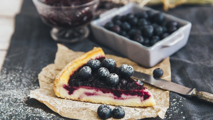 Geschnittenes Stück Käsekuchen mit Blaubeeren, | © Getty Images / victoriabee