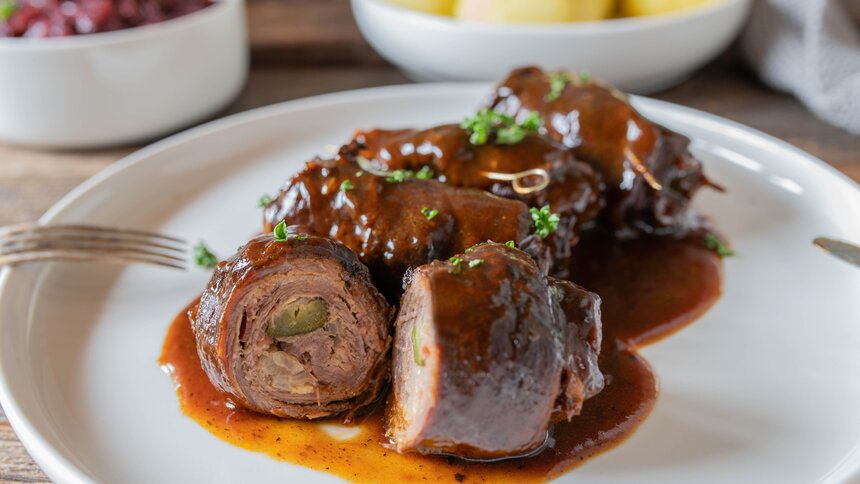 Aufgeschnittene Rinderroulade mit Rotkohl und Kartoffeln.  | © Getty Images / 	Angelika Heine