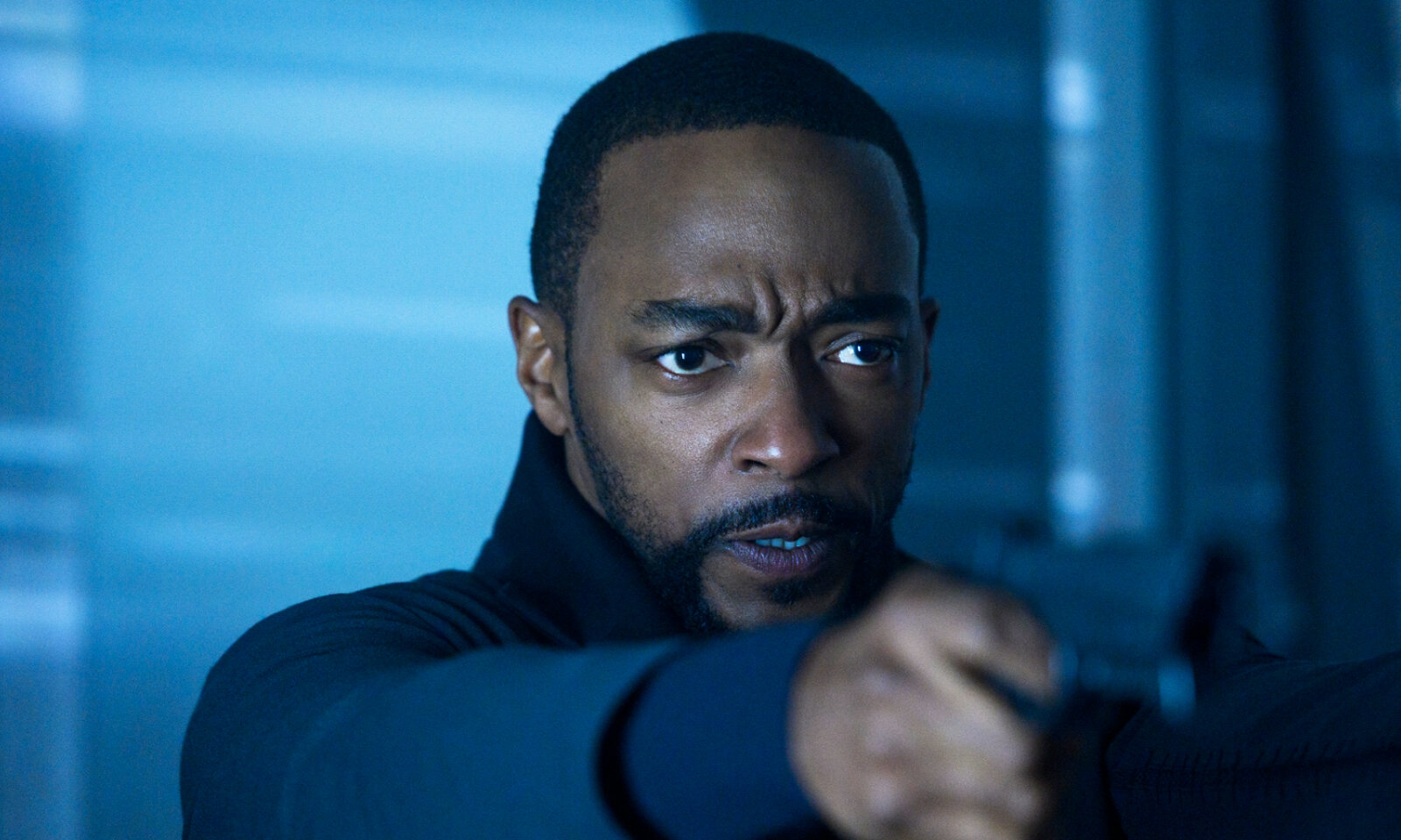 Nahaufnahme von Anthony Mackie in der Netflix-Serie "Altered Carbon" mit grimmig entschlossenem Blick und Waffe im Anschlag | © Netflix/Diyah Pera