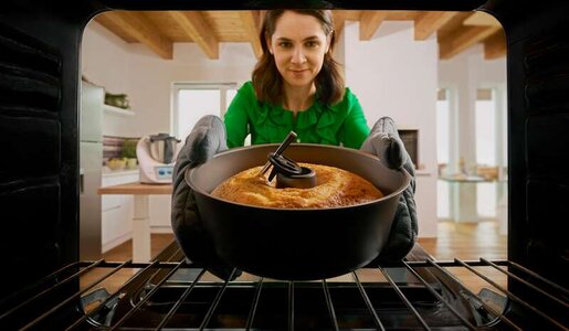 Frau schiebt Kuchen mit Thermomix-Sensor in den Backofen, Sicht aus dem Ofen heraus. | © Vorwerk