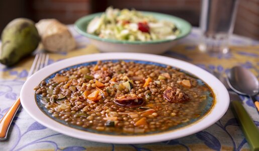Traditionelle Linsensuppe in Suppenteller auf Esstisch. | © Getty Images / kemirada