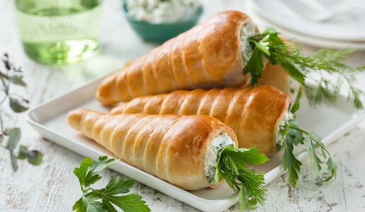 Hefebrötchen in Form von Möhren befüllt mit Frischkäsefüllung, auf einer Servierplatte liegend, angerichtet. | © Getty Images / Anna_Shepulova