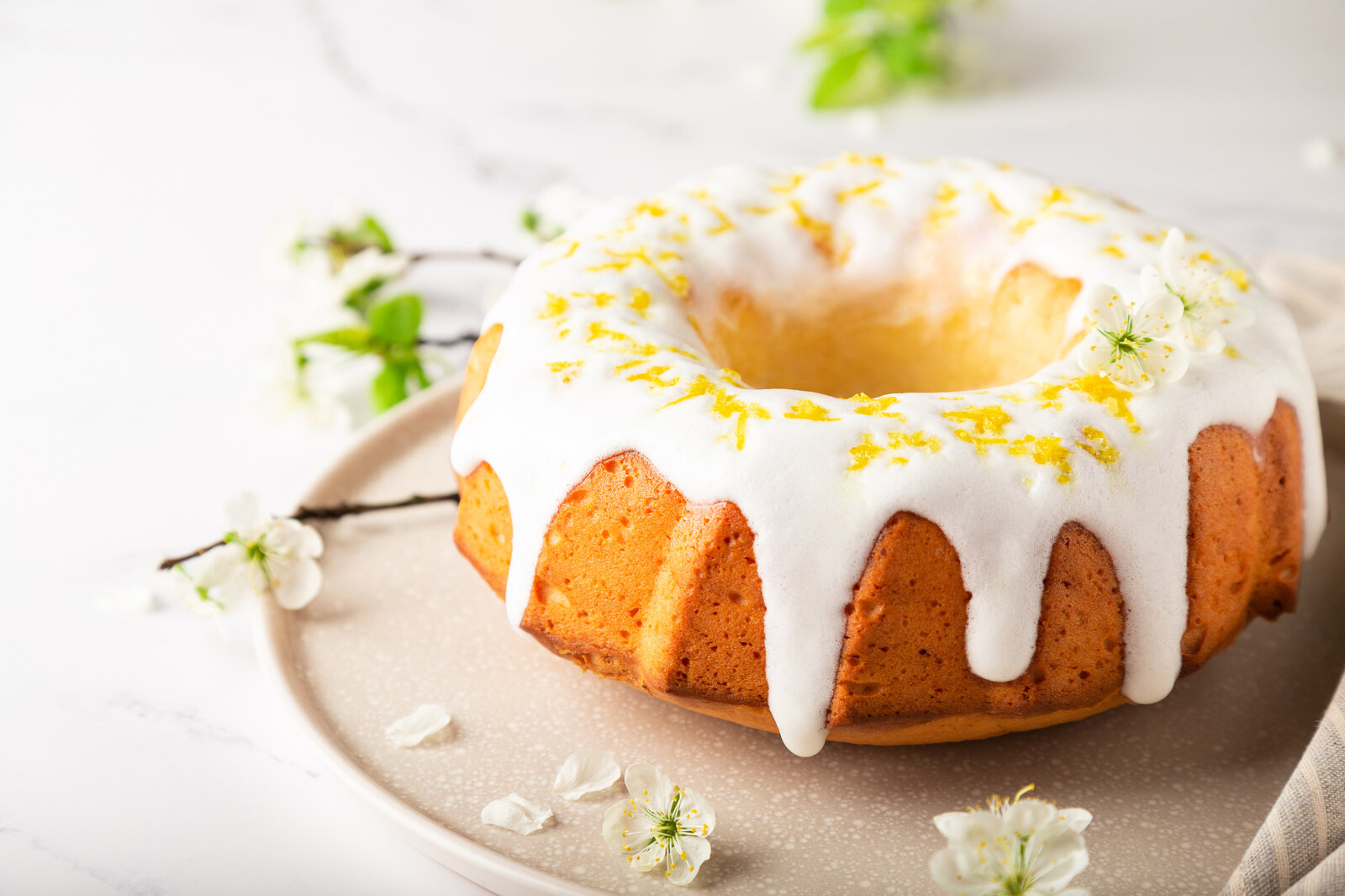 Kuchen in Gugelhupf-Form, begossen mit Zuckerguss in Frühlings-Atmosphäre. | © Getty Images / Anaiz777