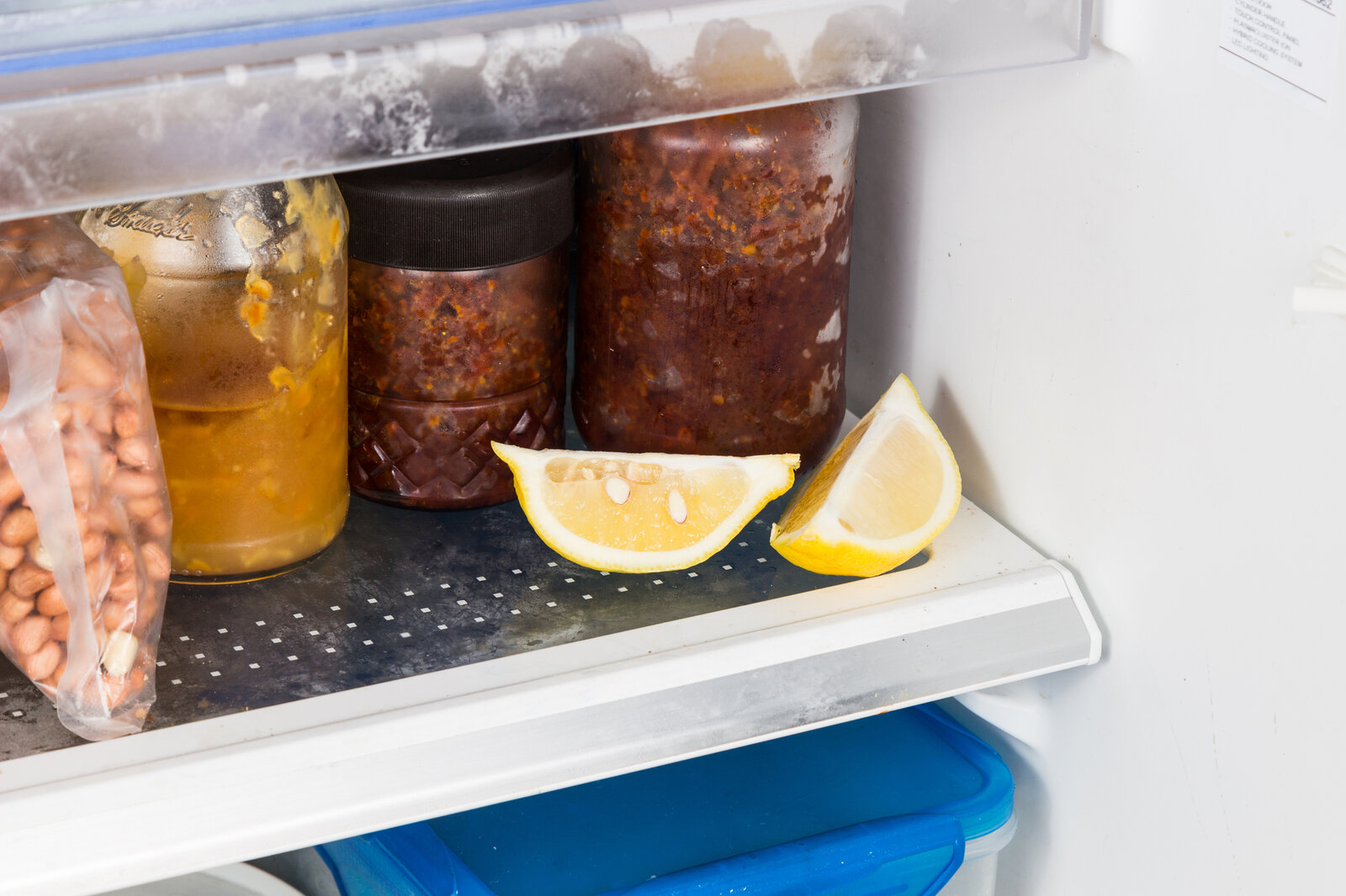 Aufgeschnittene Zitronenstücke neben Gläsern mit eingemachten Soßen im Kühlschrank. | © Getty Images/ ThamKC