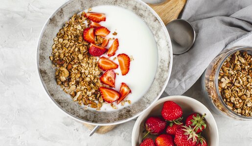 In einer Müslischüssel in einer Reihe angeordnet Granola, Erdbeeren, Chiasamen und Joghurt. | © Getty Images / Alexandr Kolesnikov