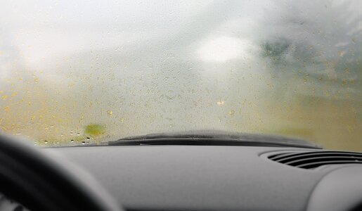 Blick aus einem Auto durch eine beschlagene Windschutzscheibe an einem regnerischen Tag, der Hintergrund ist unscharf. | © Adobe Stock/ SZ-Designs