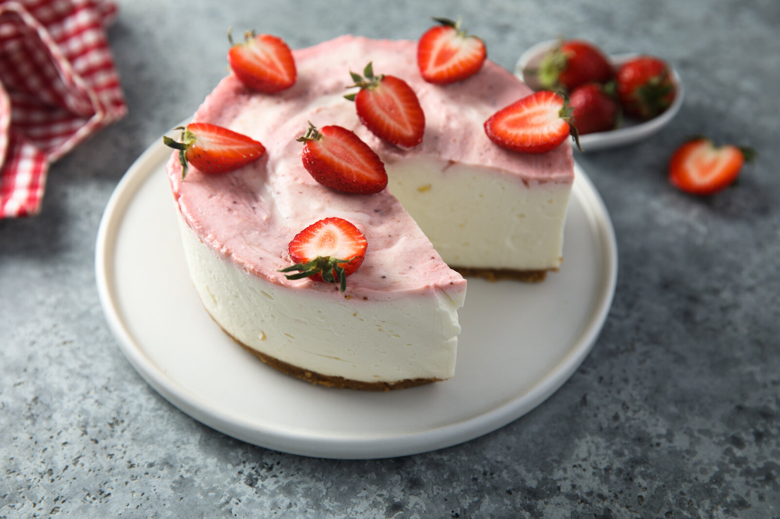 Saftiger Joghurt-Kuchen mit frischen Erdbeeren ohne Mehl, angerichtet auf Kuchenteller. | © Getty Images / Mariha-kitchen