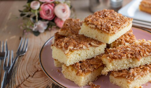 Stücke von Buttermilch-Blechkuchen angerichtet übereinander auf einem weißen Teller. | © Getty Images / Angelika Heine